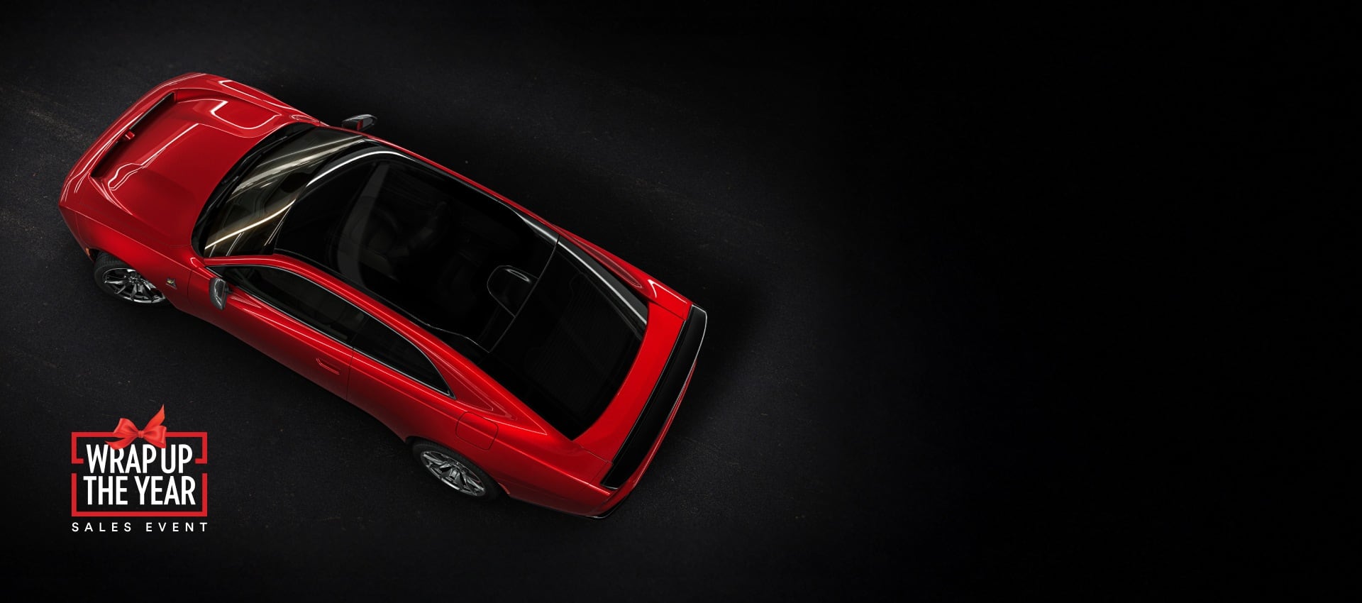 An overhead angle of a red 2024 Dodge Next-Gen Charger Scat Pack highlighting its panoramic glass sunroof. Wrap up the Year Sales Event.