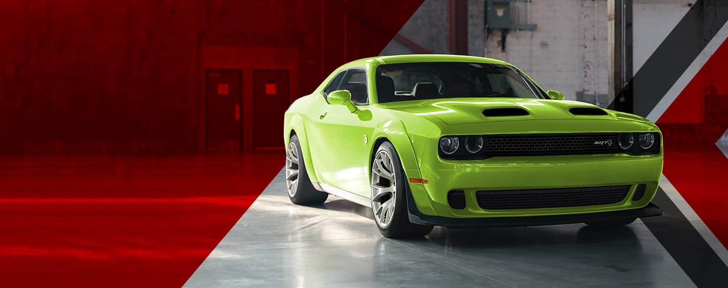 A lime green 2023 Dodge Challenger SRT Hellcat Widebody parked in an industrial garage.