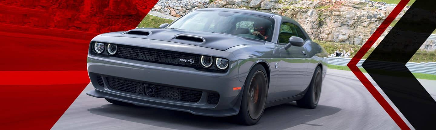 Una vista frontal en ángulo de un Dodge Challenger SRT Hellcat Redeye 2023 gris andando por una pista.