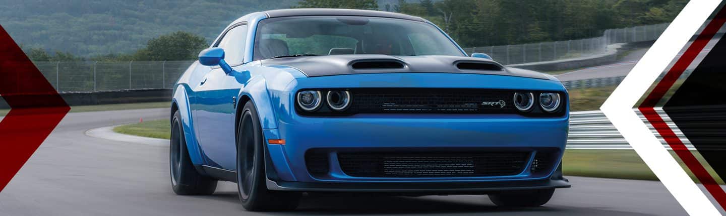 An angled front view of a blue 2023 Dodge Challenger SRT Hellcat Widebody being driven on a track.