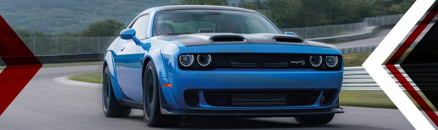 Una vista frontal en ángulo de un Dodge Challenger SRT Hellcat Widebody 2023 azul andando por una pista.