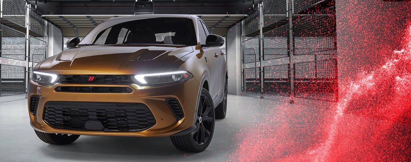 Un Dodge Hornet R/T híbrido de alto desempeño 2023 estacionado en un estacionamiento comercial.