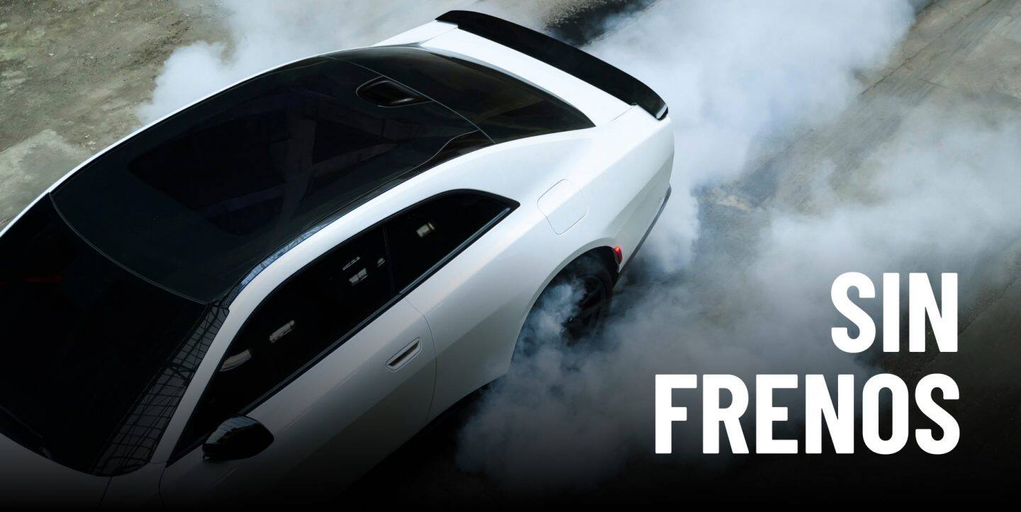 Un Dodge Charger Scat Pack 2027 blanco con techo de vidrio, rodeado de humo que sale de sus neumáticos, tomado desde arriba. Pura adrenalina.