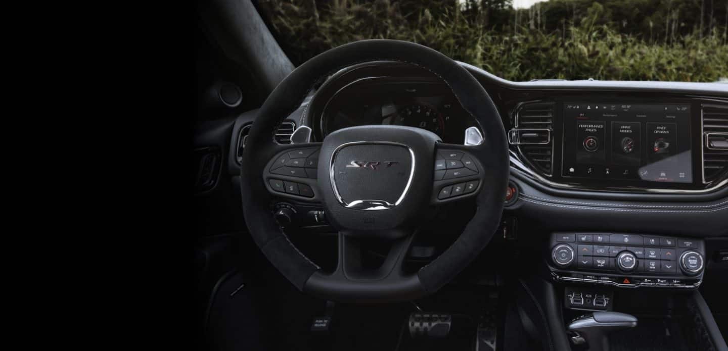 El volante, la pantalla digital en el panel de instrumentos, la pantalla táctil Uconnect y los controles de temperatura en el Dodge Durango SRT Hellcat Jailbreak 2027​​​​​​​.