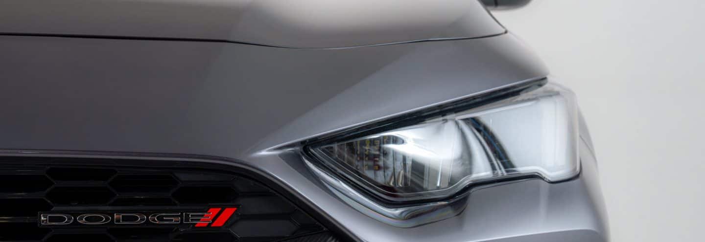 Faro delantero y parrilla de un Dodge Attitude 2026 color gris
