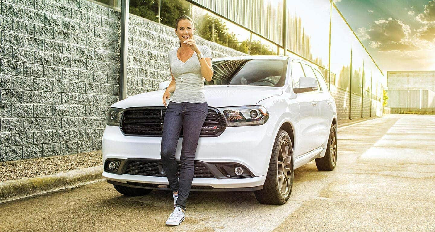 Display A woman posing in front of a 2020 Dodge Durango.