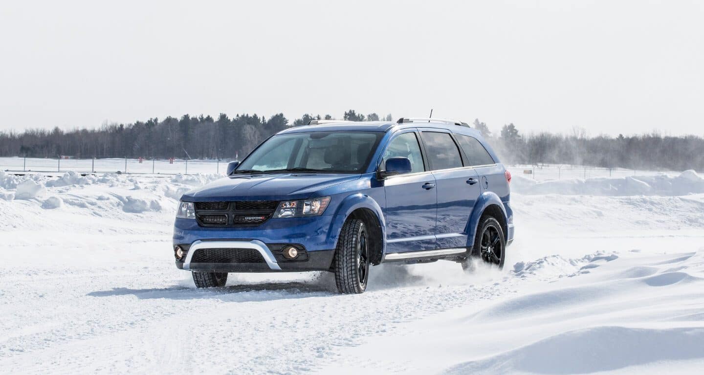 Display A three-quarter front profile of a 2020 Dodge Journey being driven on a snowy road.