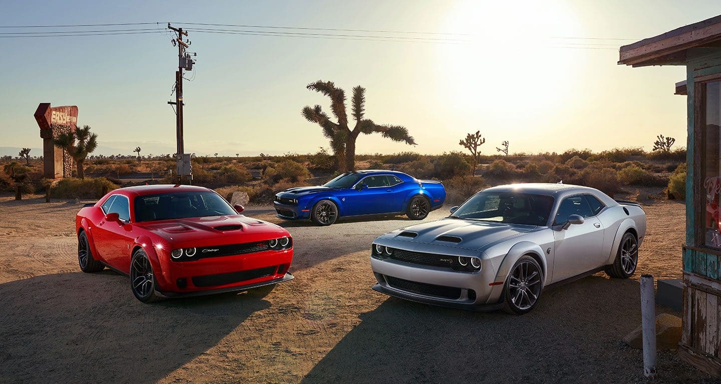 Display The 2021 Dodge Challenger SRT Hellcat Widebody, R/T Scat Pack Widebody and SRT Hellcat Redeye Widebody parked in the desert.