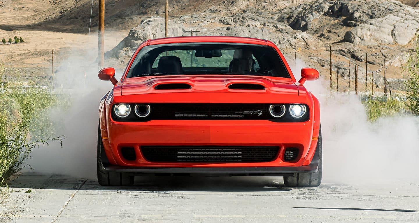 Display A head-on view of the 2021 Dodge Challenger SRT Super Stock being driven on a mountain road with smoke billowing from its rear tires.
