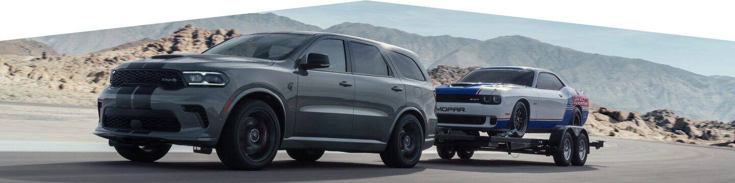The 2021 Dodge Durango SRT Hellcat towing a flatbed with a racecar on it.