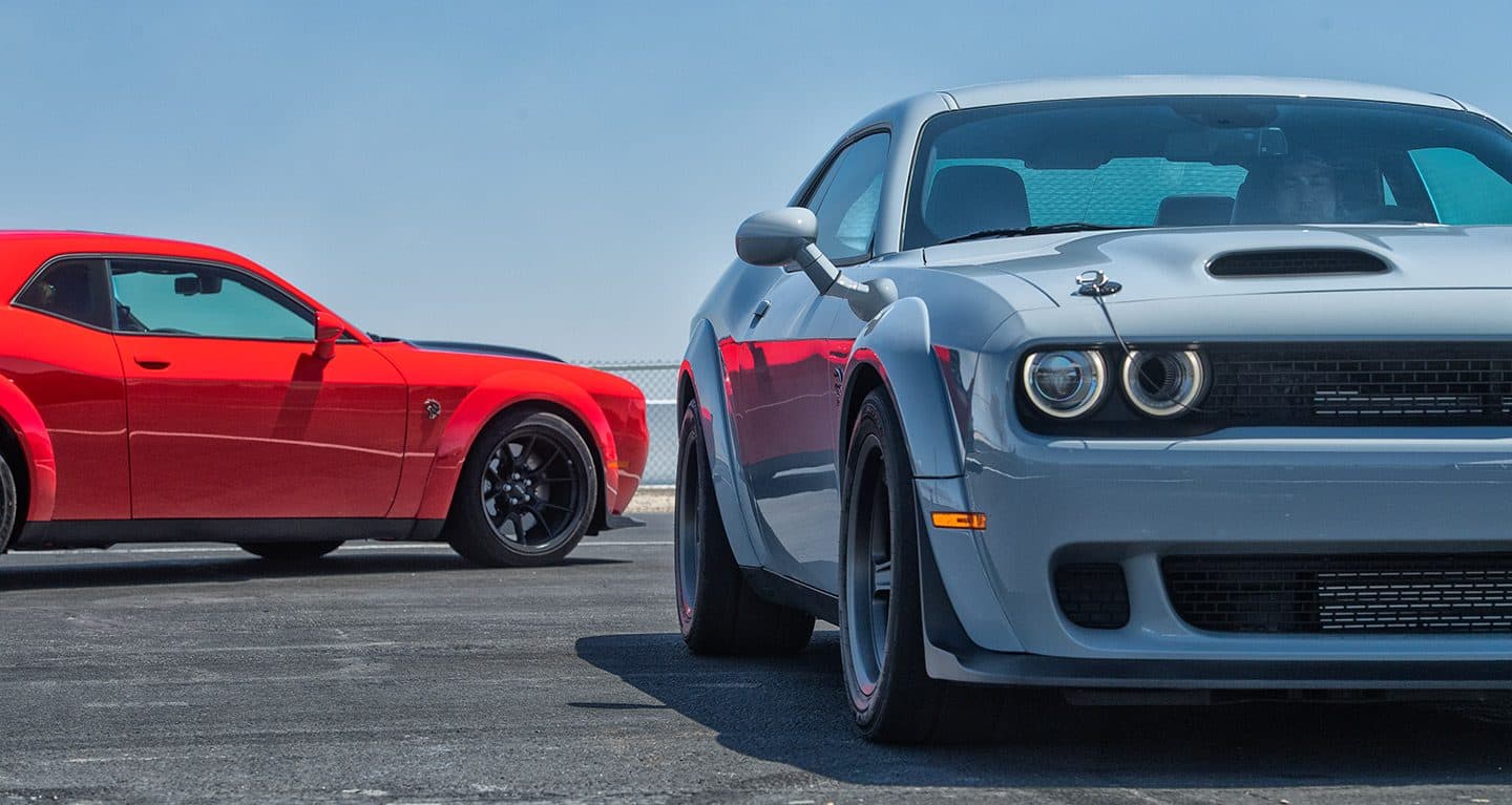 Display Driver's side of a red 2022 Dodge Challenger SRT Hellcat Redeye Widebody shown behind a white SRT Super Stock.