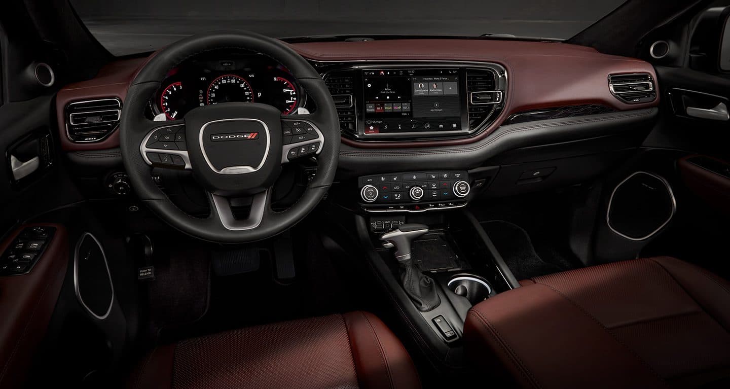 The interior of the 2022 Dodge Durango R/T focusing on the steering wheel, Uconnect touchscreen and center stack controls.