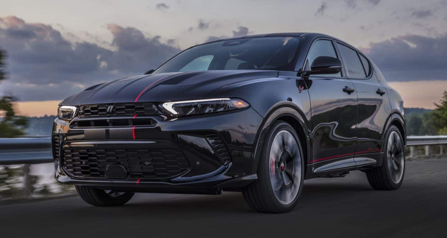 New 2023 Dodge Hornet CUV in Gray driving by a lake at dusk at Salem CDJR