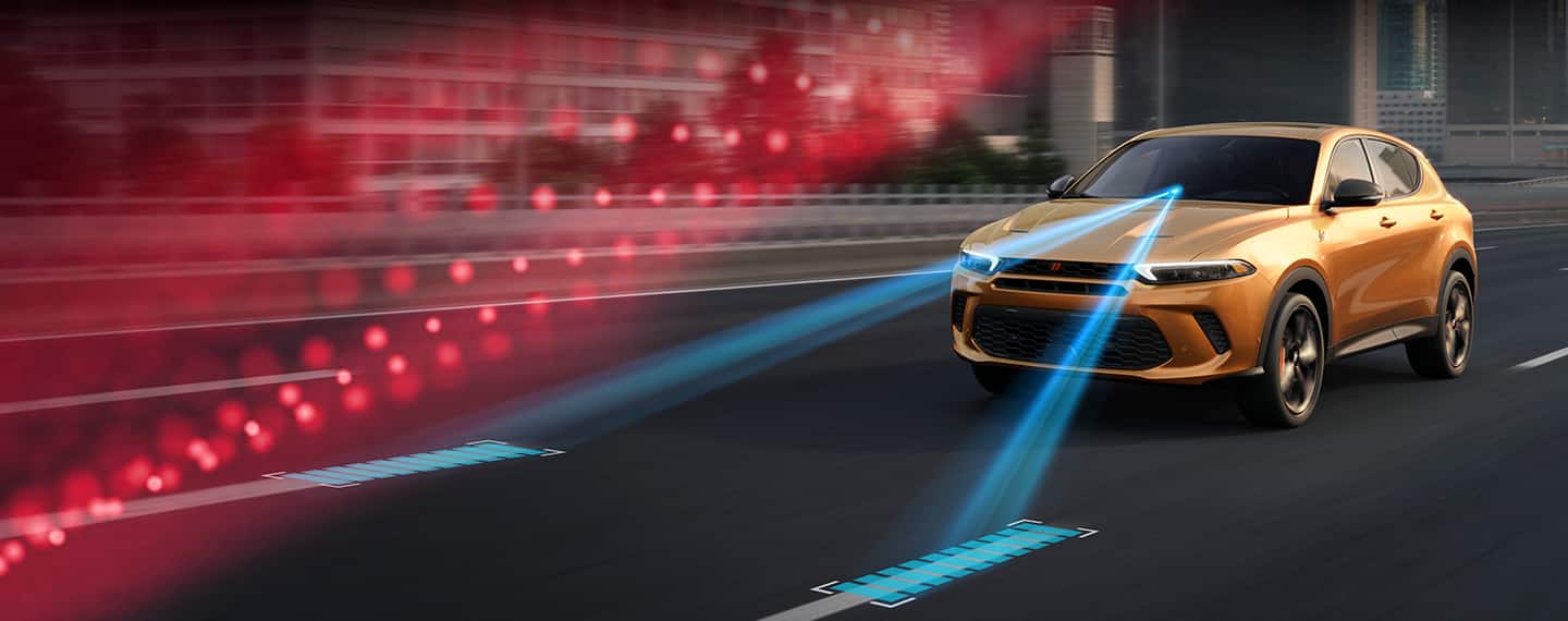 A 2023 Dodge Hornet with illustrated blue lines traveling from the bottom of the windshield to the lane markers ahead.