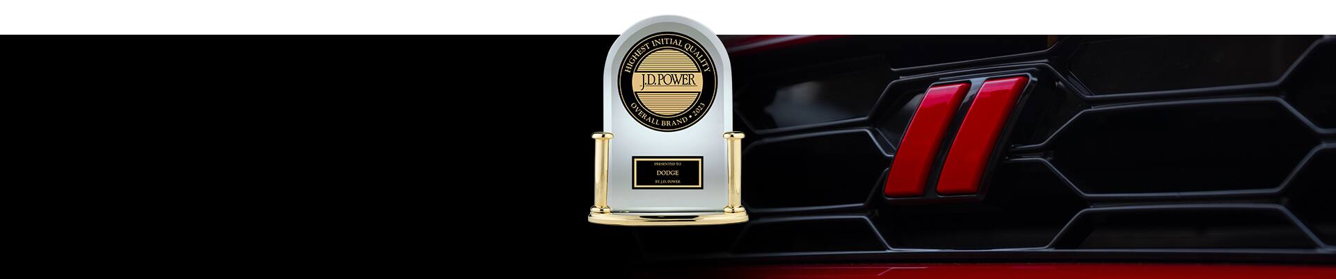 An extreme close-up of a Dodge Hornet GT grille and the J.D. Power award. Highest Initial Quality Overall Brand 2023 – Presented to Dodge by J.D. Power.