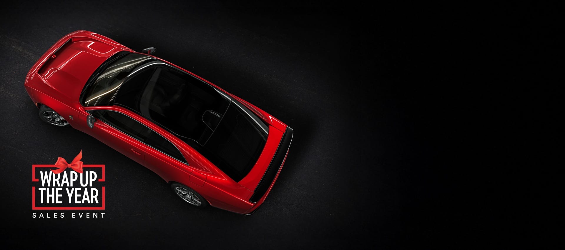 An overhead angle of a red 2024 Dodge Next-Gen Charger Scat Pack highlighting its panoramic glass sunroof. Wrap up the Year Sales Event.