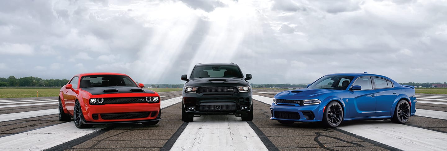 A 2020 Dodge Challenger SRT Hellcat Widebody, Durango SRT and Charger SRT Hellcat Widebody parked on an asphalt track.