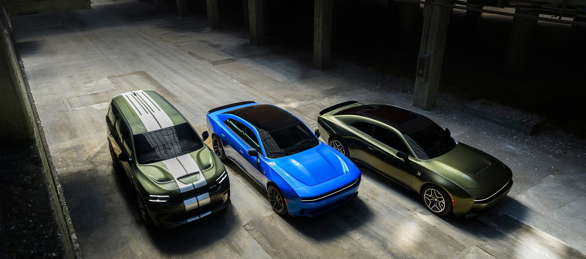 From left to right a green Durango SRT Hellcat with dual white center stripes, a blue Charger Daytona Scat Pack and a green Charger Scat Pack. 
