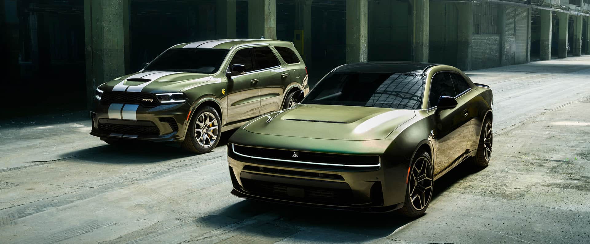 A green 2026 Dodge Durango SRT Hellcat with dual white center stripes and a green 2026 Dodge Charger Scat Pack Plus parked near each other.